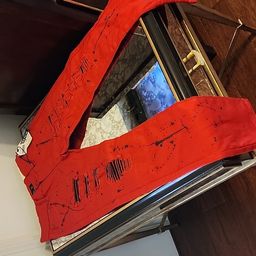 Red distressed paint splatter jeans